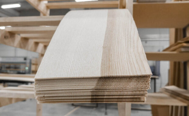 stacked lumber fills a warehouse, neatly arranged on shelving for commercial millwork designer