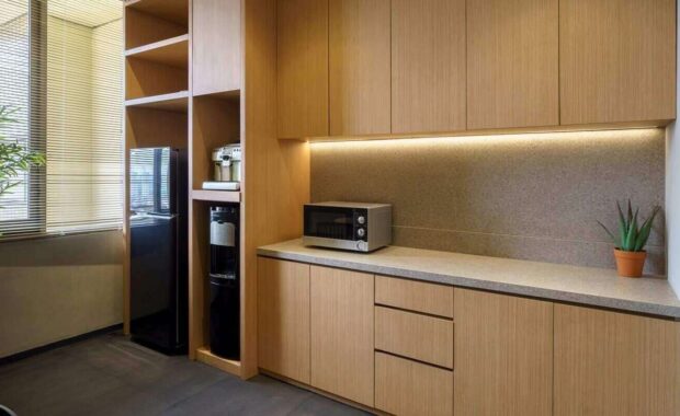 modern office pantry with wooden cabinets, microwave, and water dispenser