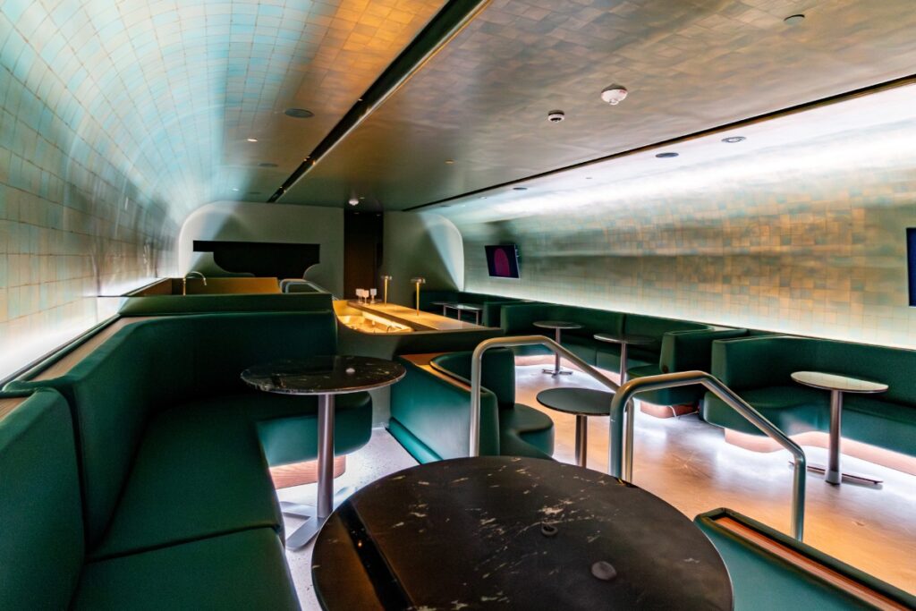 Curved tiled lounge with custom banquette seating and cocktail tables at Manifest CAW in Washington, DC.