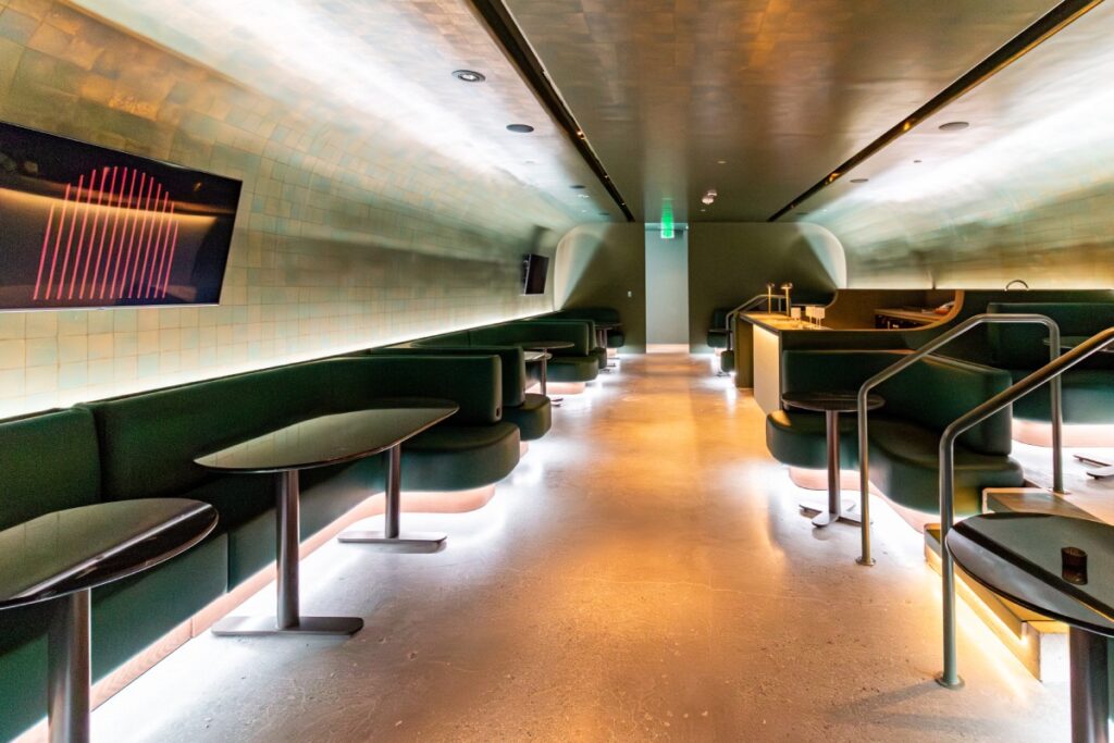 Wide view of Manifest CAW lounge showing custom banquettes, integrated lighting, and tiled walls in Washington, DC.