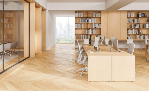 modern interior design of open office space with wooden furniture, large bookshelves, and city view through glass wall in bright natural lighting