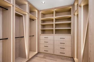 a walk in closet with wooden shelves and drawers and open shelvings