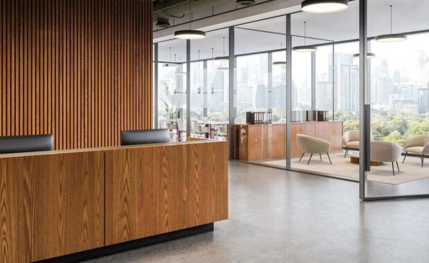 contemporary office interior with wooden reception desk and glass meeting room overlooking city skyline in bright daylight setting