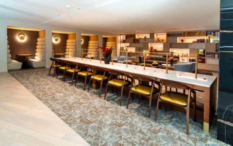A wide-angle interior of the sophisticated 1425 NY Ave lounge, showcasing a masterclass in modern corporate "hospitality" design. The space seamlessly blends high-focus work zones with relaxed social areas.